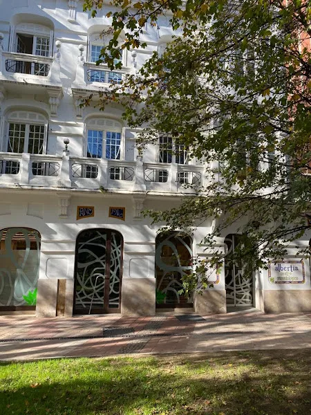 Fachada y entrada de albertia centro gerontologico con ventanas, puertas de vidrio decoradas y árboles