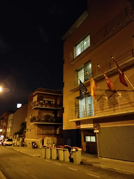 Fachada iluminada del centro de dia margarita rituerto en una calle residencial de noche
