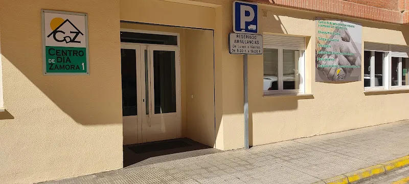 Fachada con entrada principal y cartel del centro de dia zamora 1 junto a plaza reservada para ambulancias