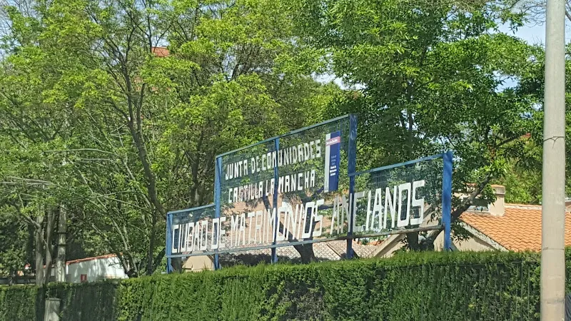 Cartel de entrada de la ciudad de matrimonios entre árboles y setos.