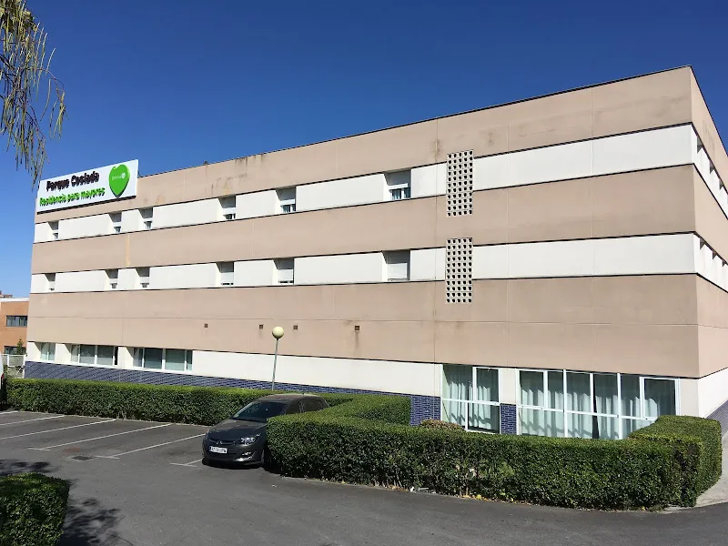 Fachada exterior del centro domusvi parque coslada con aparcamiento y setos