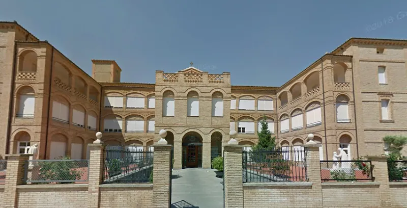 Edificio de ladrillo con entrada central y reja del hogar padre saturnino lopez novoa