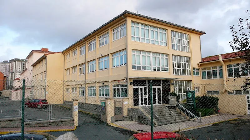 Fachada del edificio escolar la milagrosa con amplias ventanas y patio cercado.