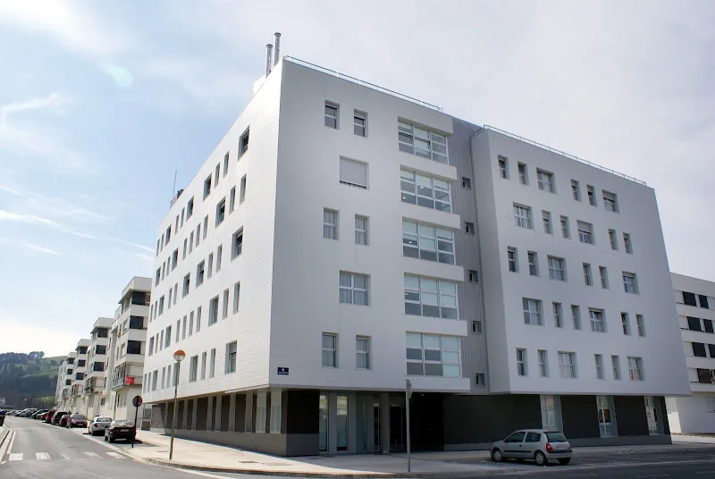 Edificio blanco de varios pisos en esquina con ventanas modernas, matia otezuri.
