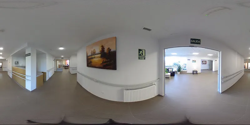 Pasillo amplio y luminoso con pasamanos y salida hacia sala común en residencia 3a edad el conquistador