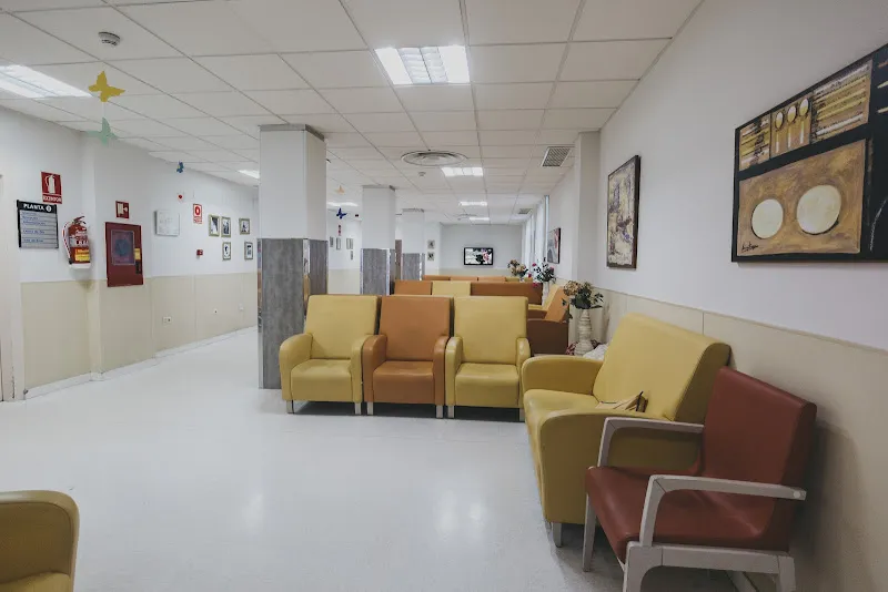 Sala de espera con sillas acolchadas en tonos amarillo y marrón en residencia ciudad jardin san jorge