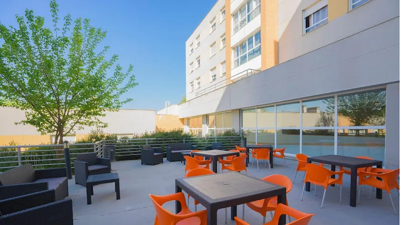 Terraza exterior con mesas y sillas en la residencia de mayores amavir villaverde