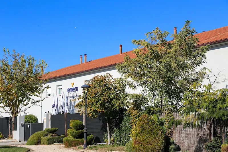 Fachada y jardines de la residencia de mayores en el alamo madrid emera con banderas en la entrada.
