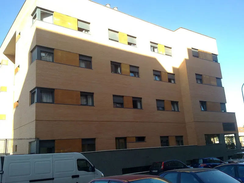 Edificio de varios pisos con fachada de ladrillo y persianas amarillas, residencia de mayores la luz