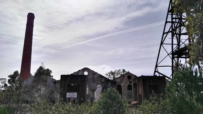 Restos de edificio industrial con gran chimenea y estructura metálica en residencia la zarza