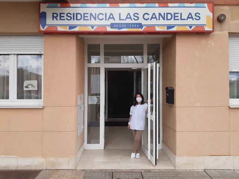 Entrada principal de la residencia las candelas burgos con profesional sanitaria en el umbral