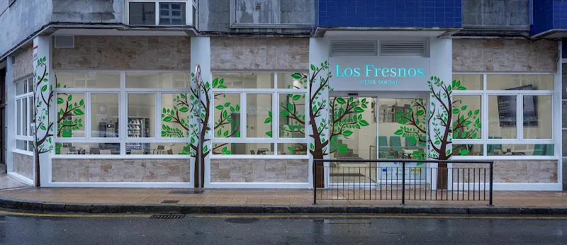 Fachada con grandes ventanales y murales de árboles de la residencia los fresnos