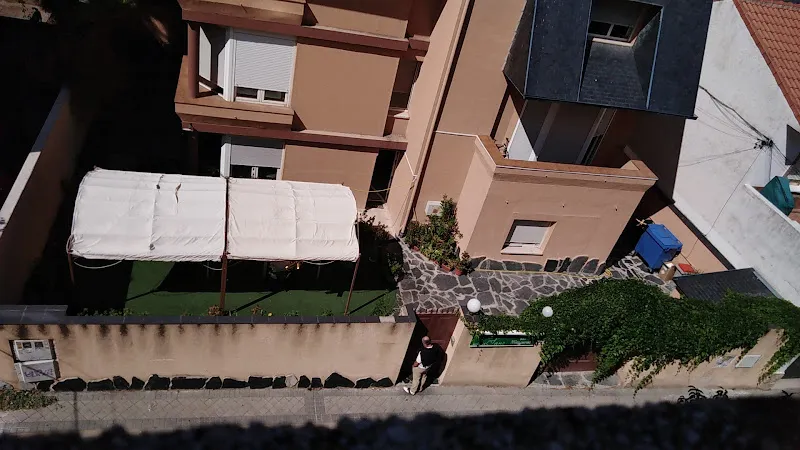 Vista aérea de la residencia lusanz con patio, cenador blanco, camino de piedra y entrada peatonal.