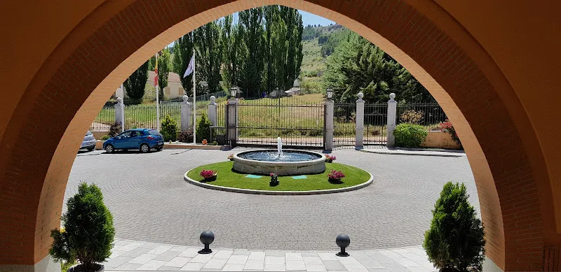 Entrada frontal vista desde un arco con fuente circular en la residencia nuestra senora de la luz