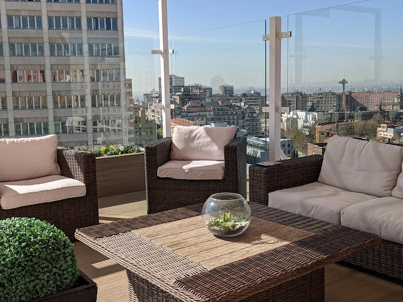 Terraza exterior con sillones de mimbre y vistas urbanas en residencia orpea madrid loreto