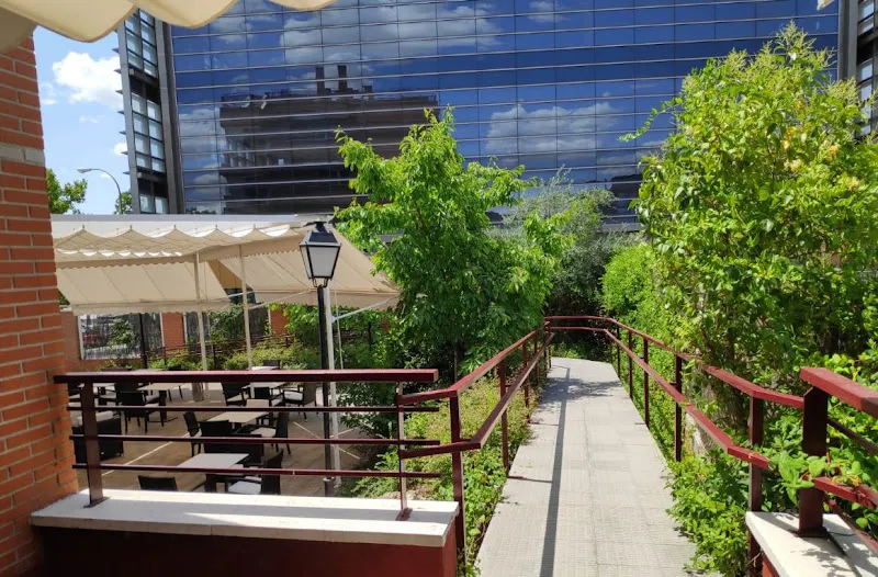 Acceso en rampa y terraza ajardinada de la residencia para mayores en alcobendas ballesol bajo un cielo soleado