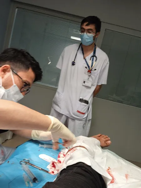 Profesionales sanitarios con mascarilla y guantes tratan un brazo con sangrado, Atención sanitaria en brazo lesionado — residencia per a la gent gran puig d en roca.