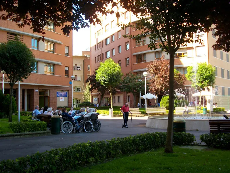 Grupo de personas mayores en el patio de la residencia rekalde junto a una fuente