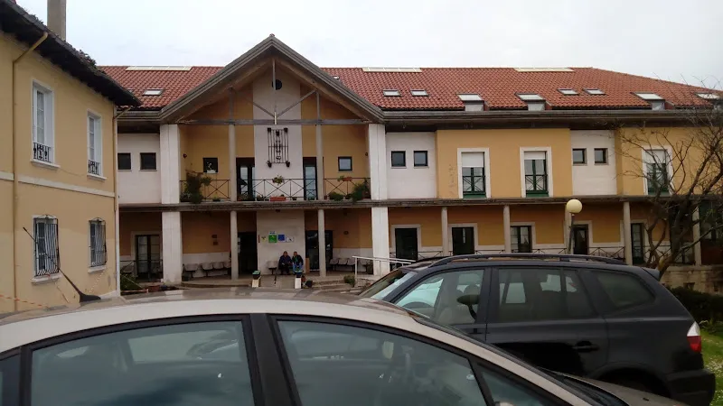 Fachada exterior con balcón, rampa de acceso y vehículos aparcados en la entrada de la residencia san pancracio.