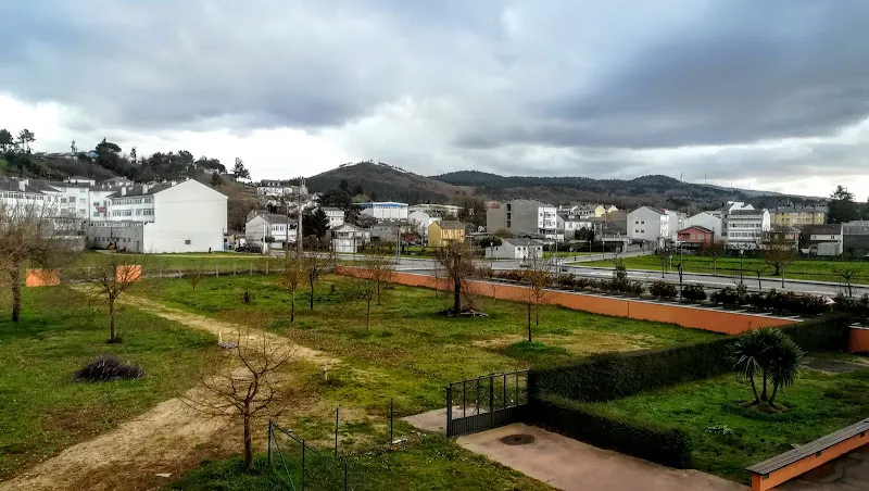Vista panorámica del área verde y edificios de la residencia serge a veiga bajo cielo nublado.