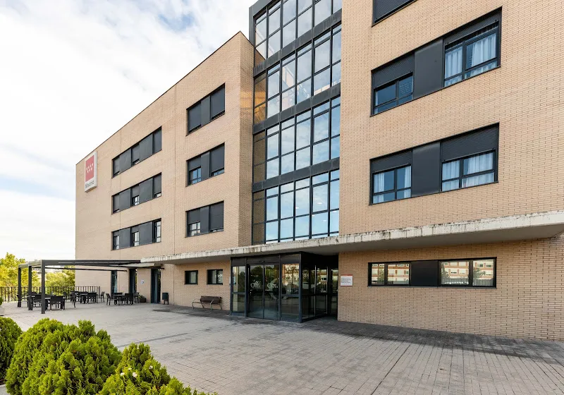 Fachada moderna y entrada de residencia y centro de dia bouco madrid sanchinarro con terraza exterior con amplios ventanales, zona de mesas y pavimento exterior.