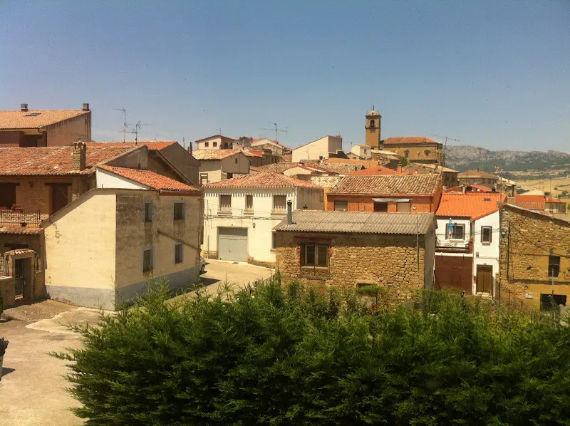 Vista de la residencia yecora con tejados de teja, torre de iglesia y paisaje montañoso al fondo
