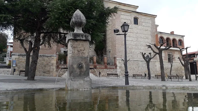 Fuente de piedra con chorros y estanque frente a un edificio de piedra en la plaza, unnamed file.
